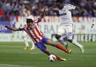 Atletico Madrid's Radamel Falcao (L) clashes with Real Madrid's Michael Essien in Madrid on April 27, 2013